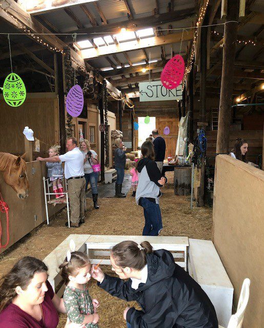 A Group of Individuals Standing Near a Horse Inside a Barn